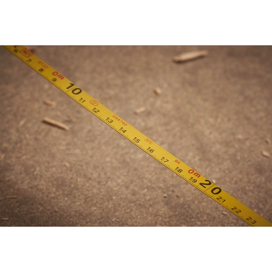 STANLEY 0-34-102 yellow measuring tape stretched on rough surface, showing clear metric markings.