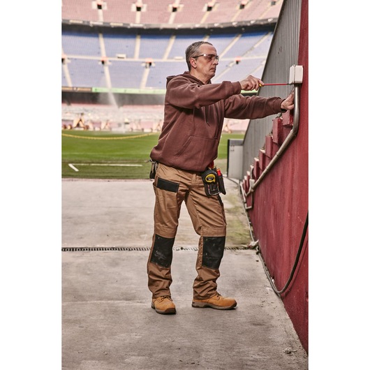 STANLEY 0-65-443 screwdriver used by a worker adjusting an outdoor electrical box near a stadium field.