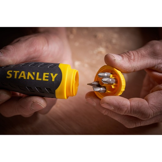 STANLEY 0-68-010 screwdriver handle with yellow cap open, showing bit storage and four bits inside, close-up.