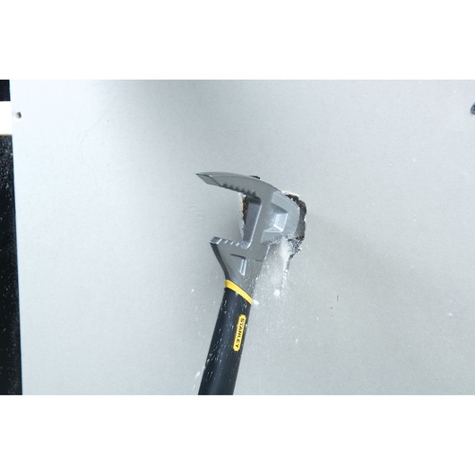 STANLEY 1-55-099 demolition hammer in action breaking drywall, close-up angle, black and yellow handle.
