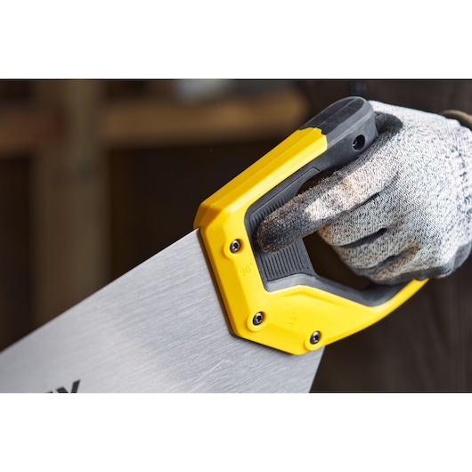 STANLEY 2-15-288 hand saw with yellow and black handle, close-up of handle held by gloved hand.