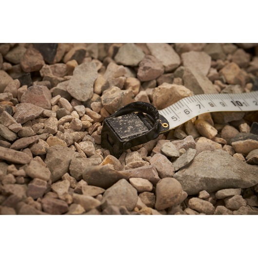 STANLEY 2-34-814 tape measure tip shown on rocky ground, close-up view, product photography.
