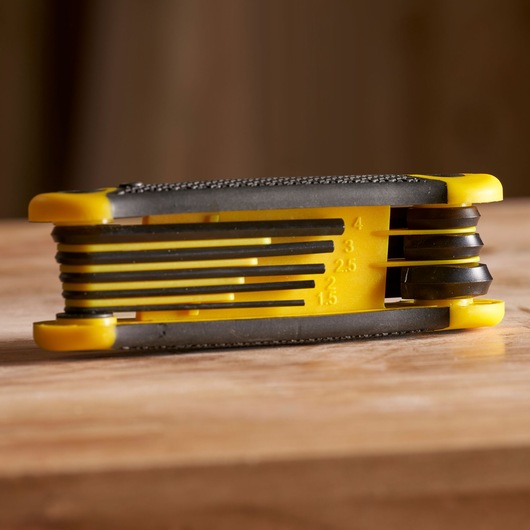 STANLEY 2-69-264 folding hex key set in yellow and black, side angle on wood surface.