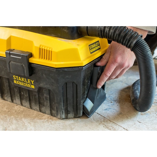 STANLEY FMC795B wet/dry vacuum with yellow lid and black body, hose attached, in use on floor.