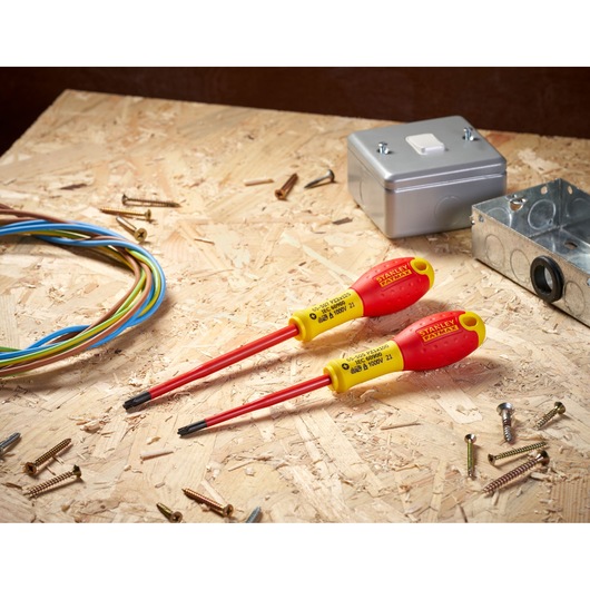 STANLEY FMHT0-62649 insulated screwdrivers on a wooden surface, surrounded by electrical wires and hardware.