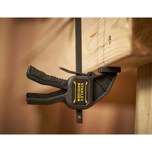 STANLEY FMHT0-83231 photography of black FATMAX bar clamp holding wooden beam.