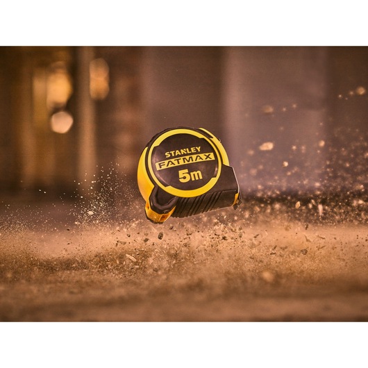 STANLEY FMHT33100-0 tape measure FATMAX 5m in black and yellow, photographed in dusty environment.