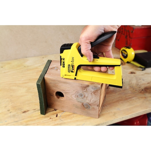 Photo of STANLEY FMHT6-70411 stapler fastening wood pieces on a workbench.