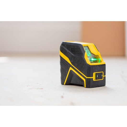 Photo of STANLEY FMHT77586-1 black and yellow cross line laser level on white background, angled view.