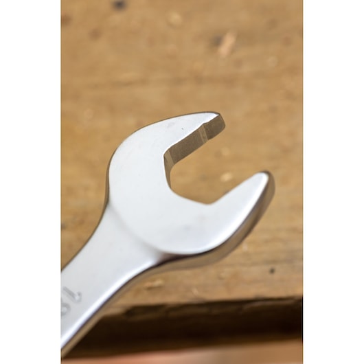 STANLEY FMMT13030-0 open-end wrench close-up with silver finish, tool resting on wooden surface.