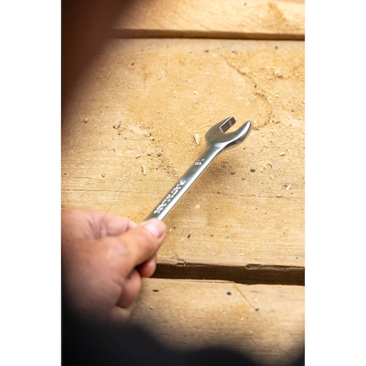 Photo of STANLEY FMMT13040-0 open-end wrench held in hand on wooden workbench.