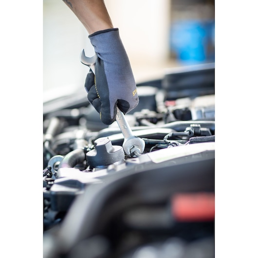 Photo of STANLEY FMMT13062-0 wrench used on car engine, black glove hand visible, product category: Photography.