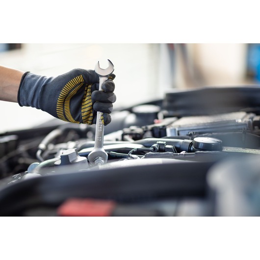 Photo of STANLEY FMMT13072-0 wrench in gloved hand working on car engine, tool details visible.