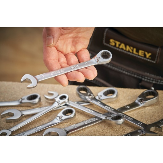 Photo of STANLEY FMMT13086-0 ratcheting spanner set held in hand, several wrenches on workbench.