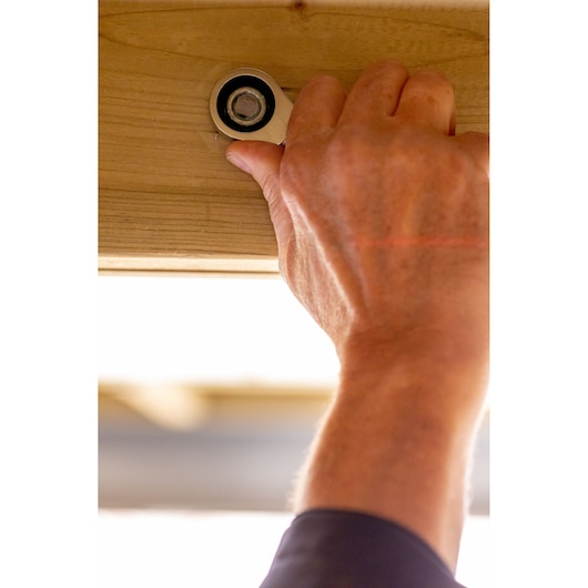 STANLEY FMMT13109-0 ratcheting wrench tightening bolt on wood beam, close-up, product in use.