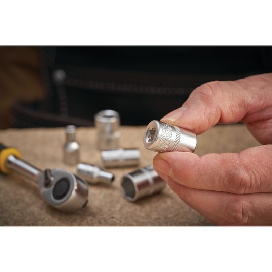Photo of STANLEY FMMT17191-0 socket held in hand, with ratchet and other sockets on work surface.