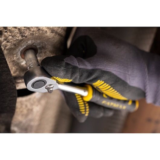 STANLEY FMMT17194-0 ratchet being used by a gloved hand on metal surface, close-up photography.