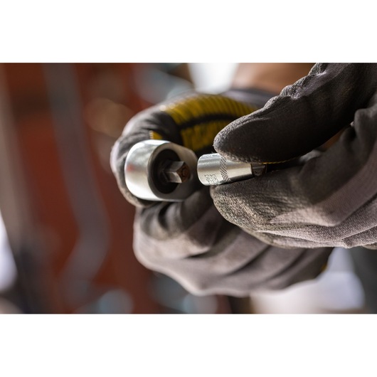 Photo of STANLEY FMMT17195-0 socket tool held by gloved hands, close-up view, photography category.