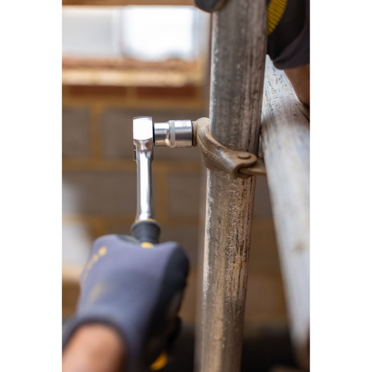 STANLEY FMMT17215-0 ratchet used to tighten a metal pipe clamp, close-up photography.