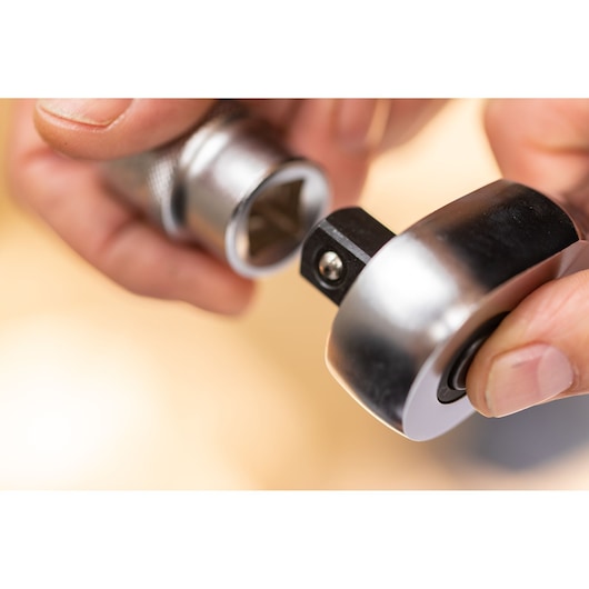 STANLEY FMMT17221-0 photography of a hand attaching a metallic socket to a ratchet wrench, close-up view.