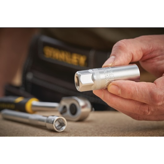 Stanley FMMT17225-0 socket held in hand, with ratchet and socket set on work surface.