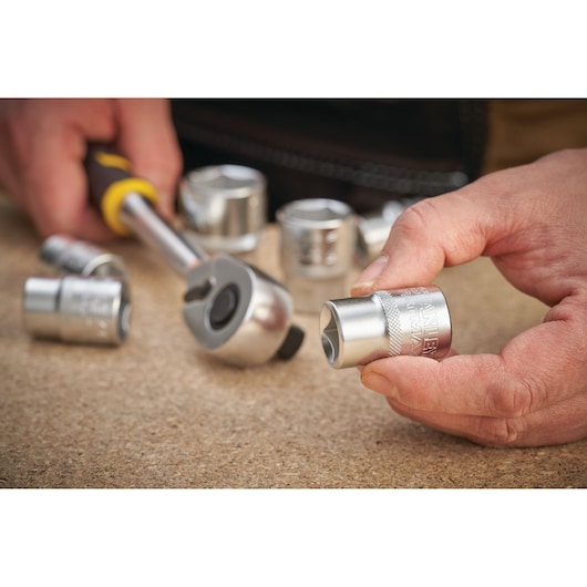 Photo of STANLEY FMMT17247-0 socket and ratchet set in use, close-up showing metallic sockets.