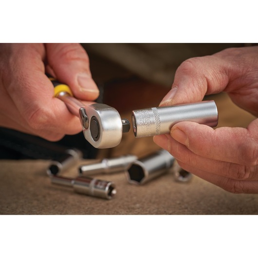 STANLEY FMMT17964-0 socket wrench and socket, close-up, held in hand, with extra sockets on work surface.