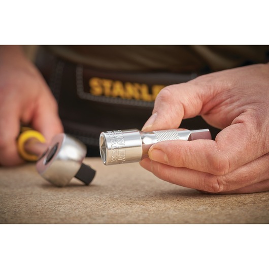 Photo of STANLEY FMMT25123-0 socket and ratchet tool held in hand, silver finish, close-up view.