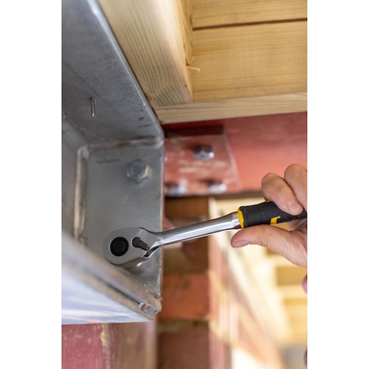 STANLEY FMMT82678-0 ratchet wrench being used to tighten a bolt on a metal beam in a construction setting.