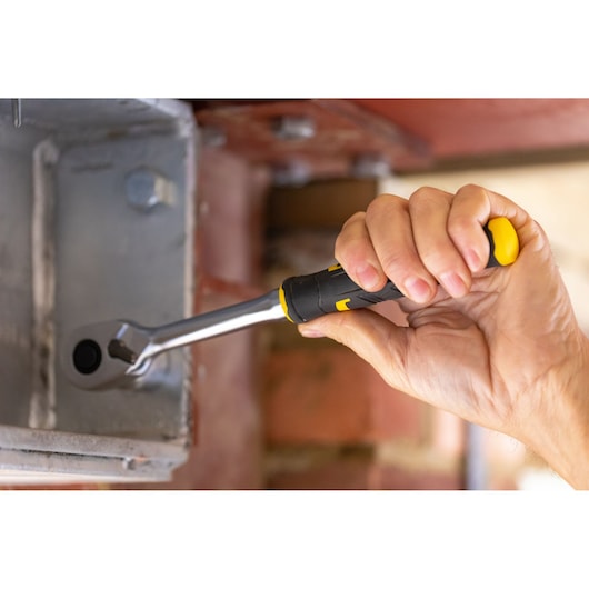 STANLEY FMMT82681-0 ratchet wrench with black and yellow handle in use tightening a bolt.