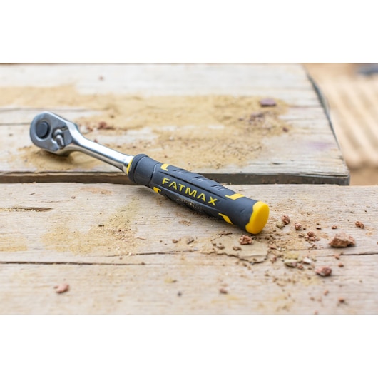STANLEY FMMT82684-1 ratchet wrench with black and yellow FATMAX handle on a sandy wooden surface.