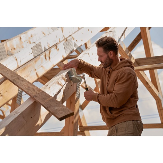 STANLEY hammer and framing accessories used for construction on wooden roof beams, outdoor setting.