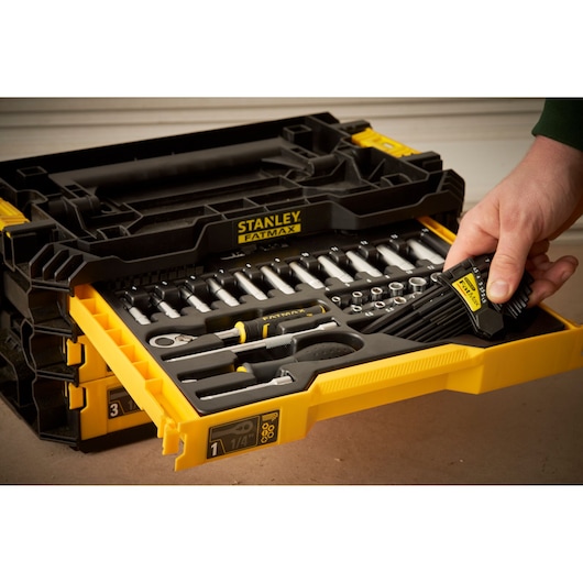 STANLEY FMMT98107-1 socket and ratchet tool set in yellow drawer, hand holding hex keys, angled view.