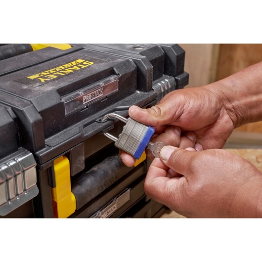 STANLEY FMST1-71981 toolbox close-up with hands unlocking padlock, showing front details.