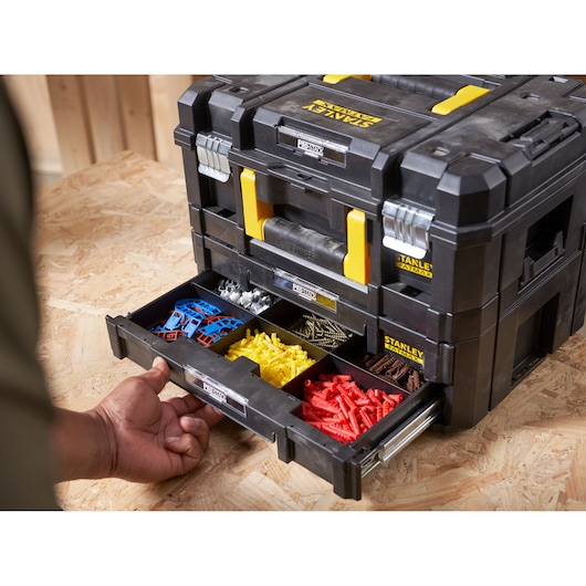 STANLEY FMST1-71981 organizer box with open drawer showing assorted hardware, black and yellow, front angle.