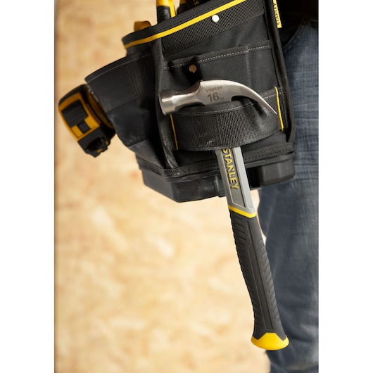 STANLEY FMST17624-1 tool belt with hammer in holder, black and yellow, close-up side view.