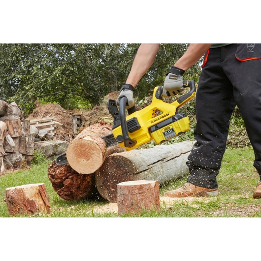 STANLEY SFMCCSB664B chainsaw cutting log outdoors, close-up action shot.