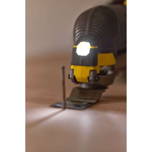 STANLEY SFMCE500B oscillating multi-tool with LED light, close-up on flat surface, blade facing forward.