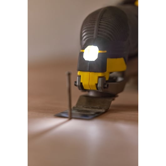 STANLEY SFMCE500D2K oscillating tool with LED light, close-up on blade and nail, front angle.