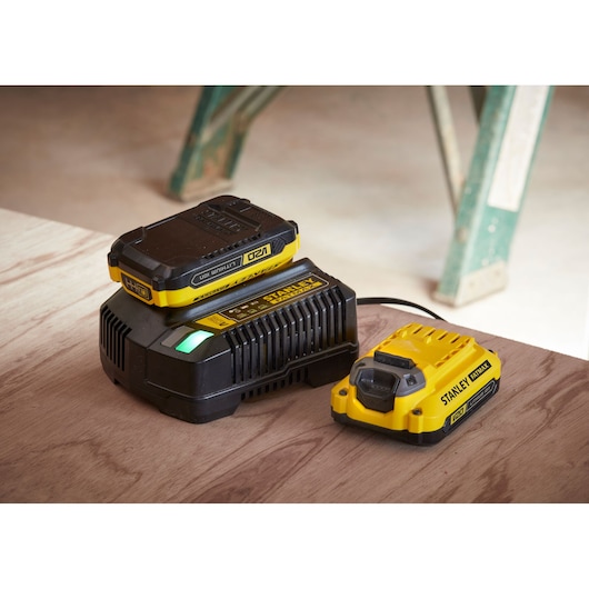 STANLEY SFMCF800C2K photography of yellow and black battery charger and battery on wood surface