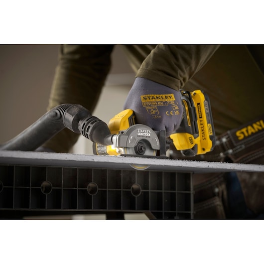 STANLEY SFMCM300B cordless cut-off tool in use cutting material, close-up side angle photography.