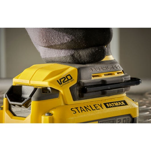 Photo of STANLEY SFMCM300B cordless brushless sander, yellow and black, side angle, in use.