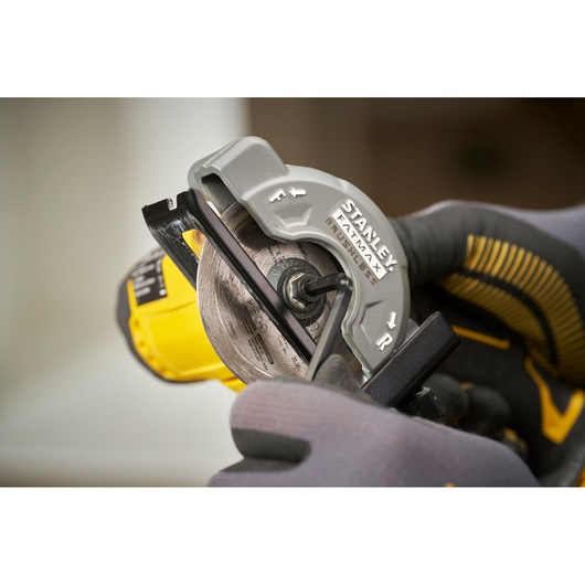 Photo of STANLEY SFMCM300B circular saw blade installation close-up with gloved hand and tool.
