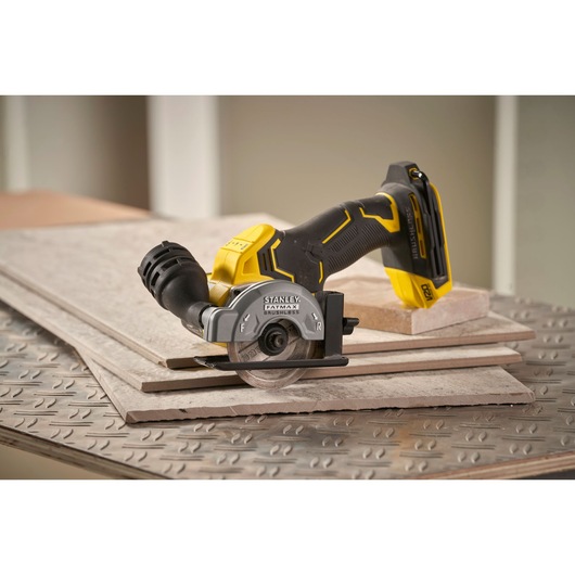 STANLEY SFMCM300D2 cordless tile saw on ceramic tiles, photography showing side angle.
