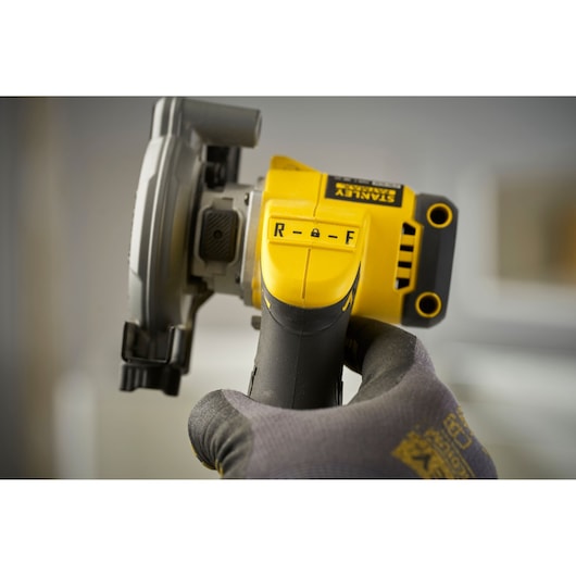 Photo of STANLEY SFMCM300D2 angle grinder handle with control switch, close-up view with gloved hand.