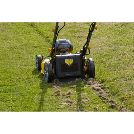 STANLEY SFMCMS2653B cordless lawn mower rear view on grass, yellow and black design, photography.