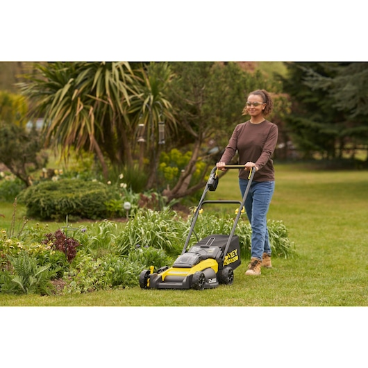 STANLEY SFMCMW2651M lawn mower in use outdoors on grass, yellow and black design, side view.