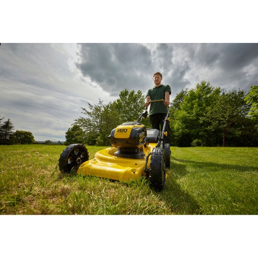 STANLEY SFMCMW2653B yellow walk-behind lawn mower on grass, low angle outdoor photography.