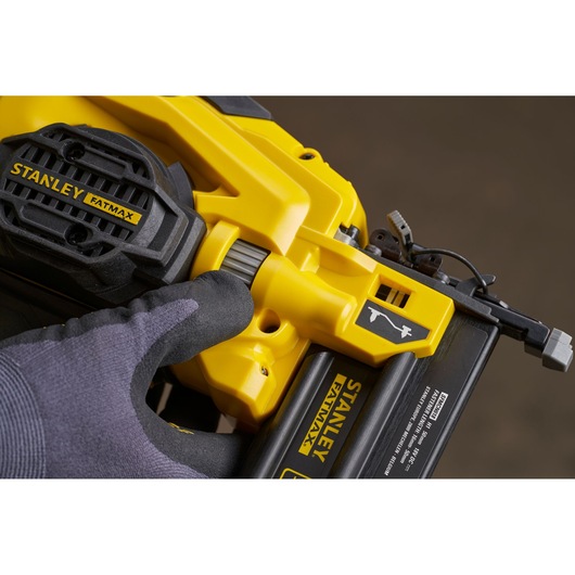 Photo of STANLEY SFMCN618B-XJ nailer tool close-up, yellow and black, showing adjustment dial and branding.