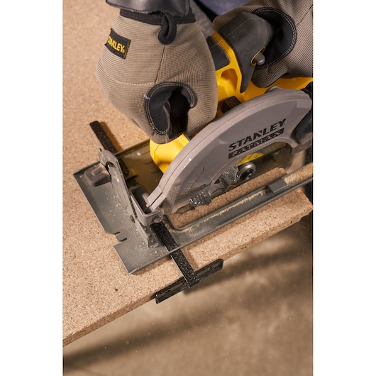 STANLEY SFMCS500M2K circular saw cutting wood, close-up view of tool and gloved hands.